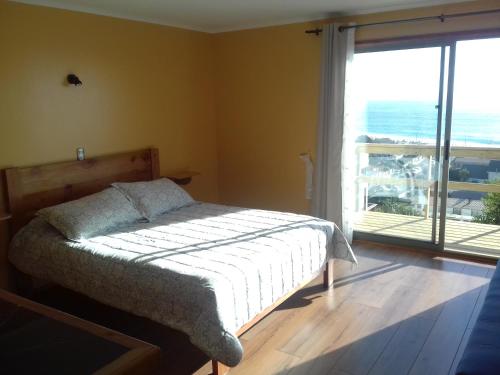 a bedroom with a bed and a large window at Cabaña Vista Bahia Algarrobo in Algarrobo