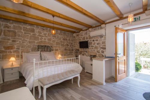 a bedroom with a bed and a stone wall at Koko Apartments in Korčula