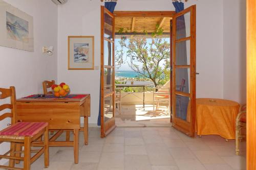 Cette chambre comprend un bureau et une porte donnant sur un balcon. dans l'établissement Askella, à Ágios Prokópios
