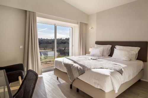 una camera da letto con un letto grande e una grande finestra di Pestana Gramacho Residences a Ferragudo