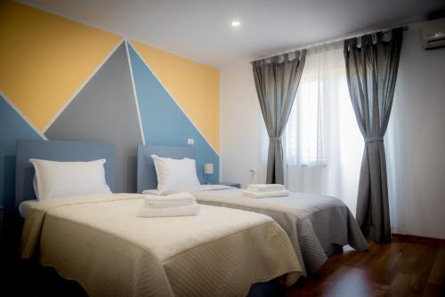 two beds sitting next to each other in a room at Pensiunea Danubio in Dunavăţu de Jos