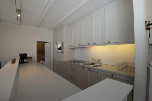 a kitchen with white cabinets and a counter top at Panorama 59 in Arolla