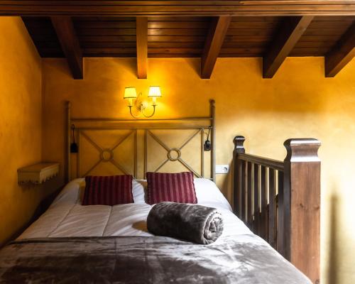 een slaapkamer met een groot bed met een houten hoofdeinde bij Acogedor Refugio en la Vall d'Incles in Incles