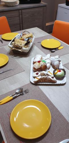 a table with yellow plates and food on it at B&B Raggio di Sole in Porto Empedocle