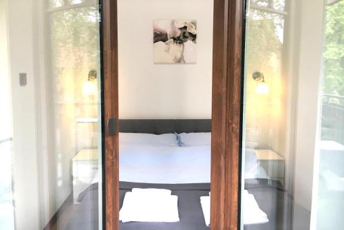 eine Glastür, die zu einem Bett in einem Zimmer führt in der Unterkunft Apartamenty Polanica Zdrój in Polanica-Zdrój