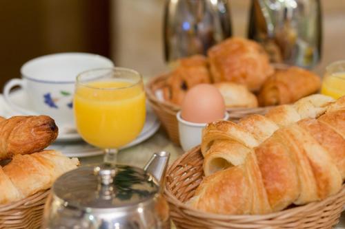 a table with baskets of bread and eggs and orange juice at Hôtel Beaubourg in Paris