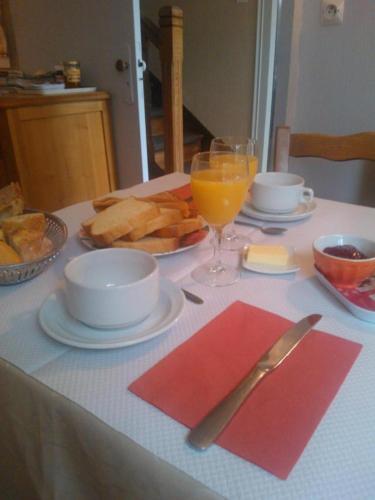 a table with plates of food and a glass of orange juice at Pension de Kerioual in Roscoff