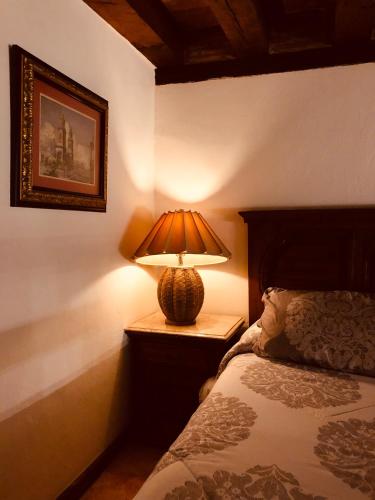 a lamp sitting on a night stand next to a bed at Casa Eugenia Hotel in Morelia