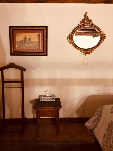 a room with a table and a mirror on a wall at Casa Eugenia Hotel in Morelia