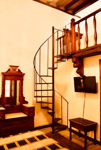 a living room with a spiral staircase and a television at Casa Eugenia Hotel in Morelia