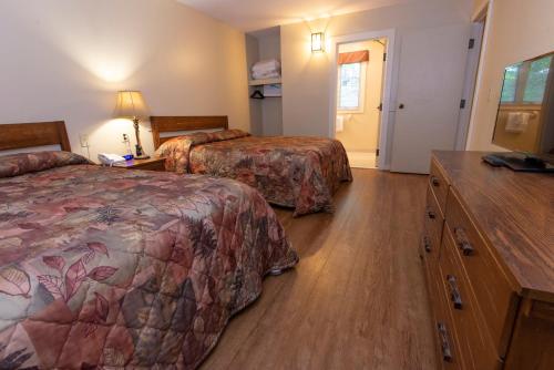 a hotel room with two beds and a dresser at Cumberland Falls State Resort Park in Honeybee