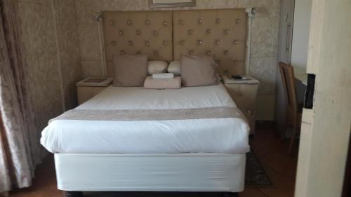 a bedroom with a large bed and two night stands at Diphororo guest house in Mogwase