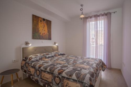 una camera con un letto con una trapunta sopra di Apartman Madonnina a Cres