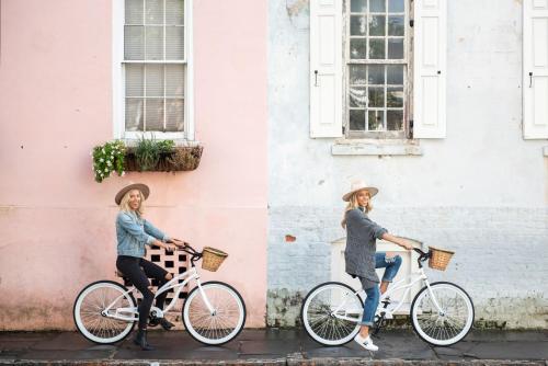a woman riding a bike next to a building at The Restoration Hotel in Charleston