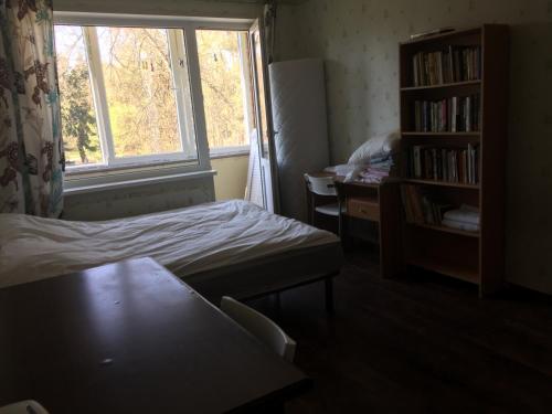 Habitación pequeña con cama y ventana en Lattino pietura en Riga