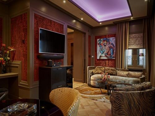 ein Wohnzimmer mit einem TV und einem Sofa in der Unterkunft Hotel TwentySeven - Small Luxury Hotels of the World in Amsterdam