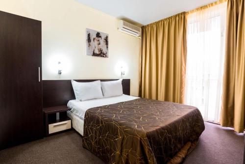 a hotel room with a bed and a window at hotel Yanis in Lozenets