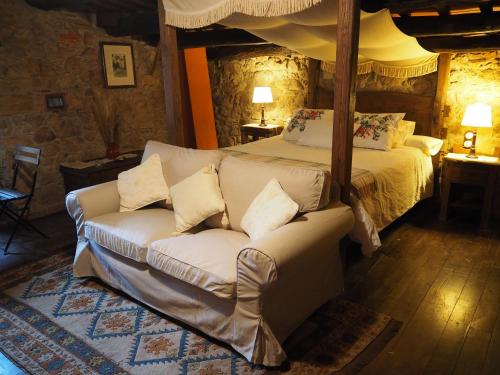 a living room with a bed and a couch at Mas Cal Sastre in Sant Hilari Sacalm