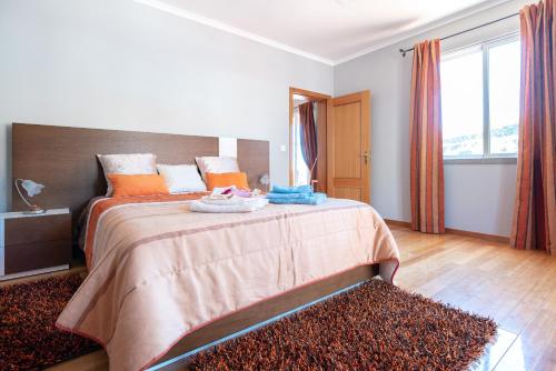 Un dormitorio con una cama grande con almohadas naranjas. en Apartment Laranjeiras, en Calheta