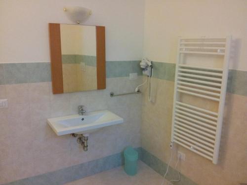 ein Bad mit einem Waschbecken und einem Spiegel in der Unterkunft Tellus Saturnia in Saturnia