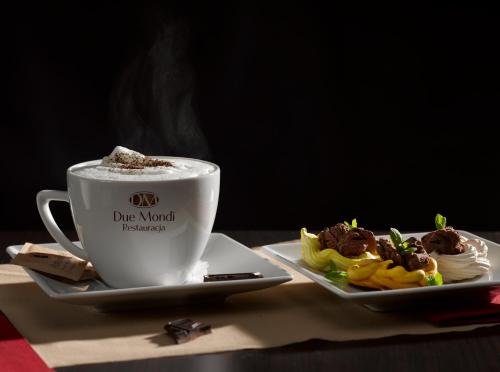 a cup of coffee next to a plate of food at Aura - Hotel & Restaurant & Sauna in Zielona Góra