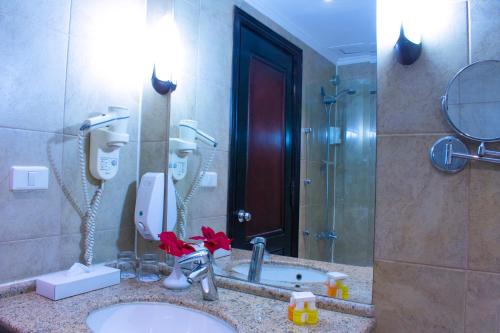 a bathroom with a sink and a shower and a mirror at Parrotel Aqua Park Resort in Sharm El Sheikh