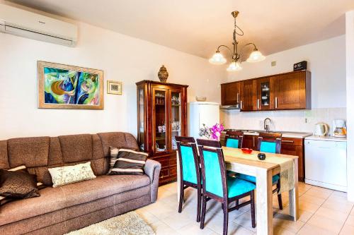 a living room with a couch and a table and a kitchen at Apartments Lidija in Rogoznica