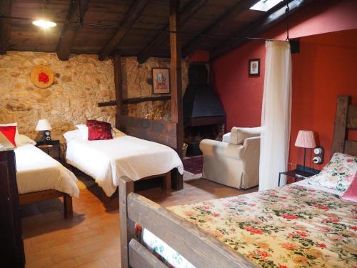a bedroom with two beds and a stone wall at Mas Cal Sastre in Sant Hilari Sacalm