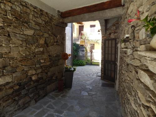 an alley in a building with a stone wall at Guest House Casa del Folletto in Stresa