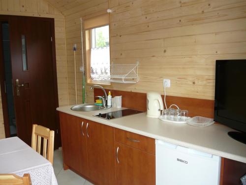 uma cozinha com um lavatório e uma bancada em Domki Sara em Władysławowo