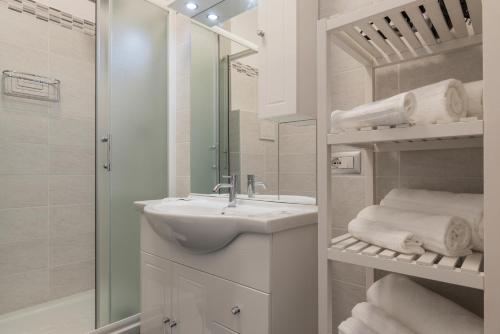 bagno bianco con lavandino e specchio di Nomentana White Apartments a Roma