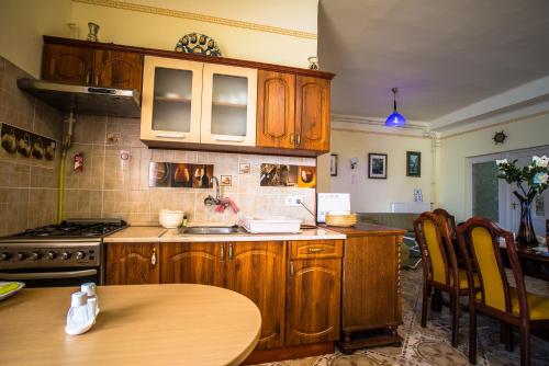 a kitchen with wooden cabinets and a wooden table and a tableablish at Mickey's Thermal Apartments in Tiszakécske