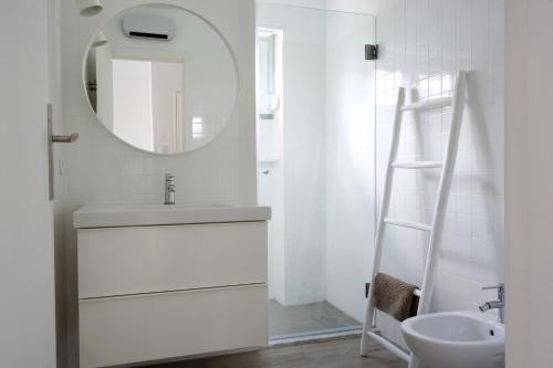 a white bathroom with a sink and a mirror at Apartamento modeno e acolhedor com terraço in Montijo