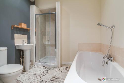 a bathroom with a tub and a toilet and a sink at Tyler’s Rest in Belfast