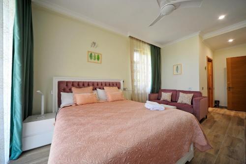 a bedroom with a large bed and a couch at Guest House Botanical Paradise in Mtsvane Kontskhi