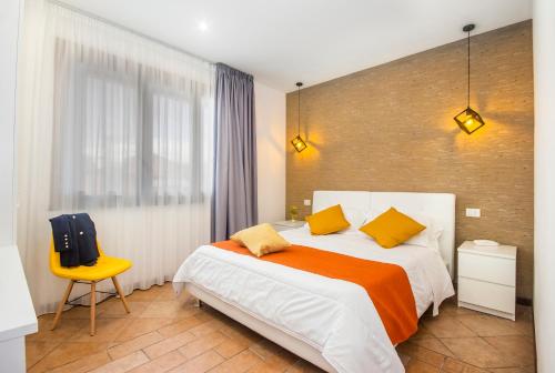 1 dormitorio con 1 cama grande y 1 silla amarilla en Mareneve Resort, en Linguaglossa