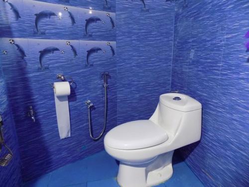 a bathroom with a toilet and a mural of dolphins at Saino ADKD Homestay Darjeeling in Darjeeling