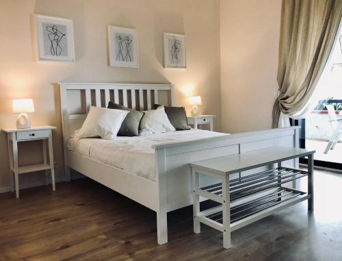 a bedroom with a white bed and a table at Taliari Taormina Apartment in Taormina