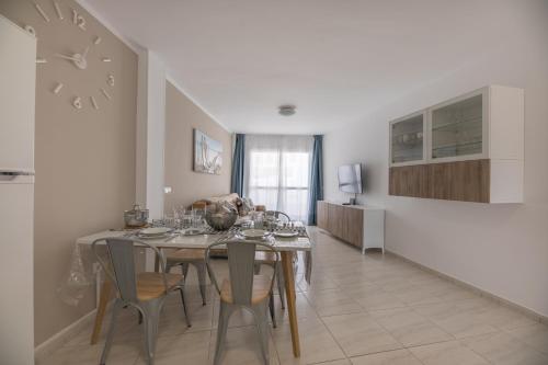 a kitchen and dining room with a table and chairs at attico vista oceano e città 3 camere 3 bagni WiFi AC in Morro del Jable
