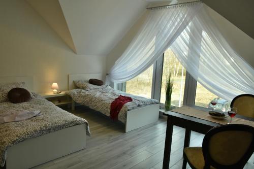 a bedroom with two beds and a window at Apartamenty Akacjowa Villa106 in Nędza