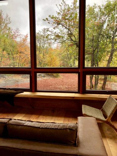 a room with a large window with a couch and a chair at Chalet Ciprés in Las Trancas