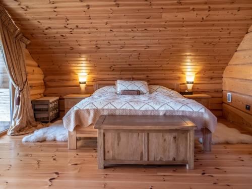a bedroom with a bed in a log cabin at Privatus rąstinis namas su pirtimi in Dėckiai