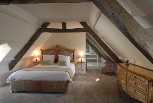 sypialnia z dużym łóżkiem na poddaszu w obiekcie Domaine de Bayeux w mieście Bayeux