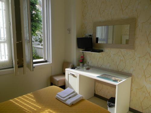 1 dormitorio con cama y escritorio con espejo en Villa Vittoria Tropea B&B, en Tropea