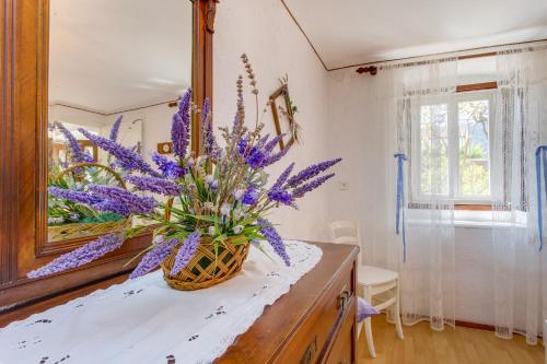 a vase of purple flowers on a counter in a bathroom at Apartment Carmen in Veli Lošinj