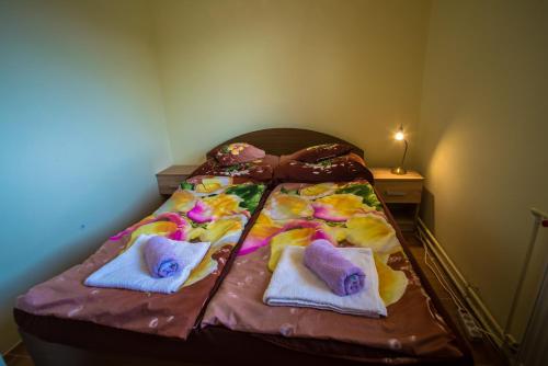 a bed with two towels on top of it at Mickey's Thermal Apartments in Tiszakécske