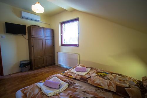 a bedroom with a bed with two towels on it at Mickey's Thermal Apartments in Tiszakécske
