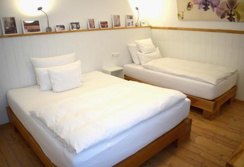 two beds with white sheets in a room at Penthouse mit 4 Schlafzimmer Warum-ins-Hotel in Neckarsulm