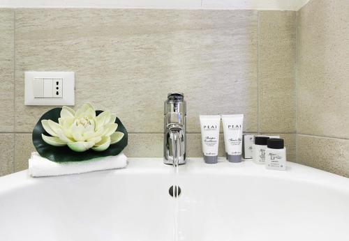 een badkamer met wastafel met bloem bij Yourbanflat Appiani in Padua