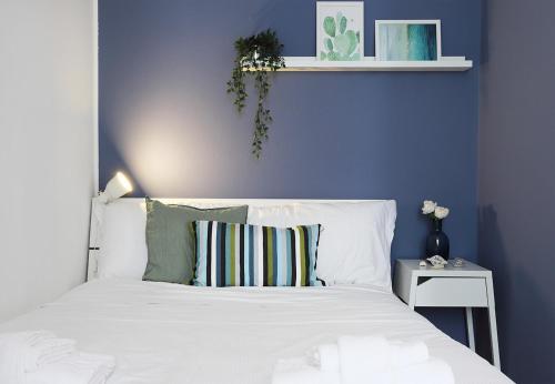 een slaapkamer met een wit bed en een blauwe muur bij Yourbanflat Appiani in Padua
